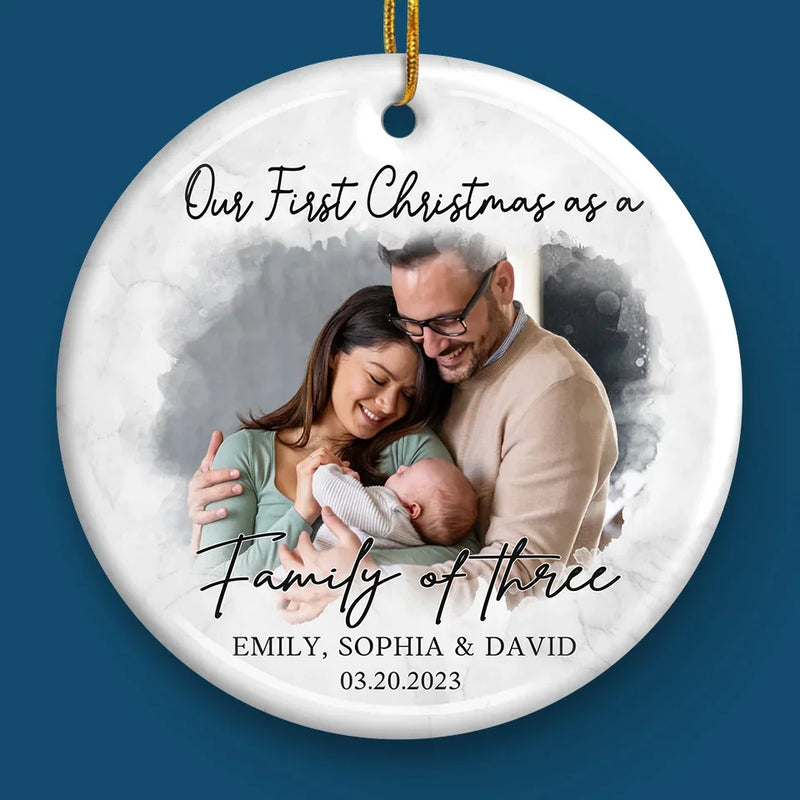 Custom Photo Our First Christmas As A Family Of Three - Couple Personalized Custom Ornament - Ceramic Round Shaped - Christmas Gift For Husband Wife, Anniversary, First Christmas